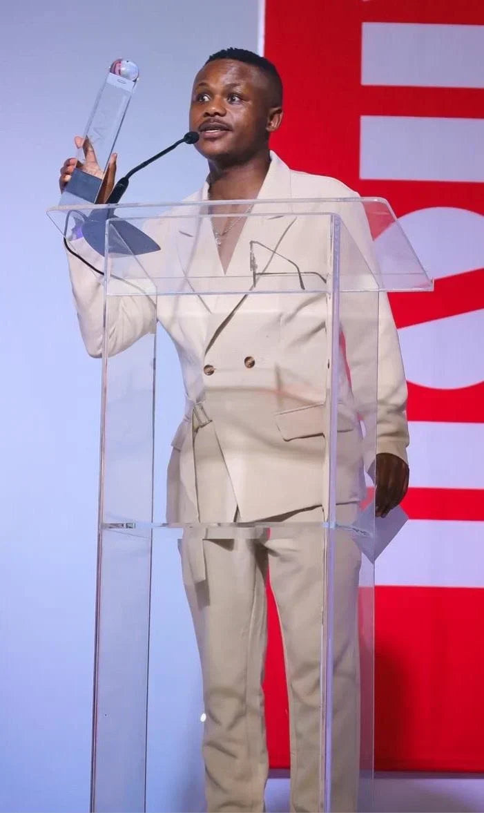 Ndivhuwo Muhanelwa accepting an award at a podium