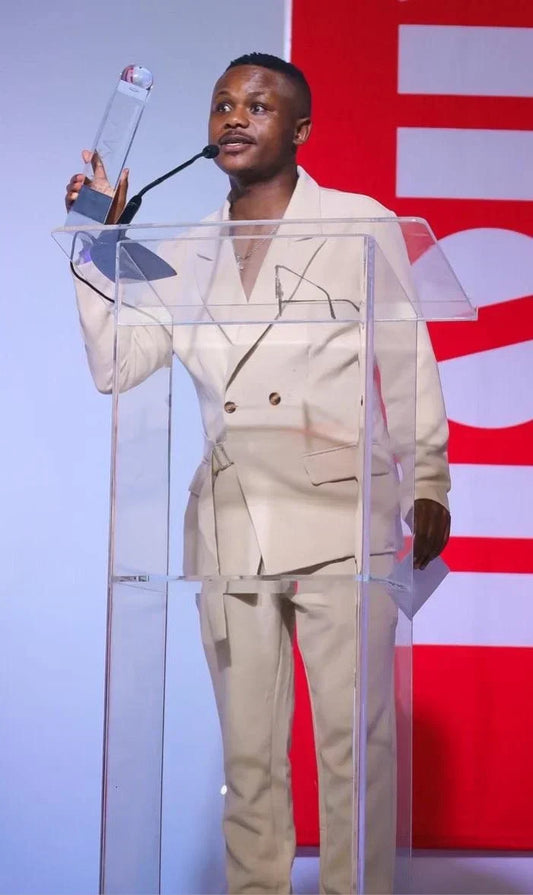 Ndivhuwo Muhanelwa accepting an award at a podium